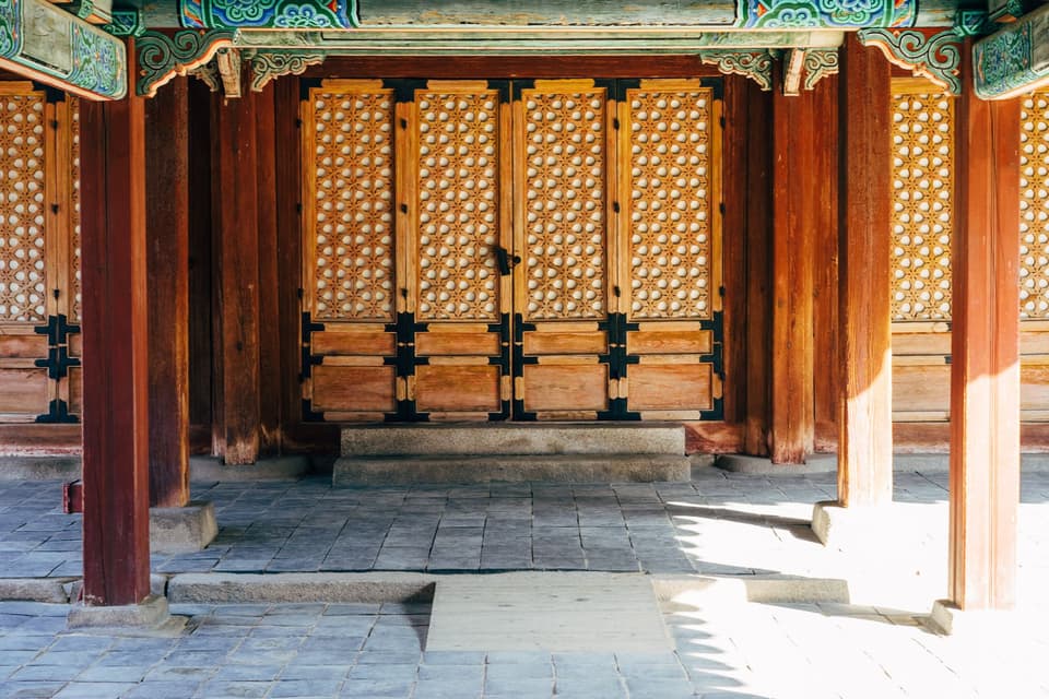 Beautiful wooden doors of a traditional Korean palace entrance in Seoul, South Korea.