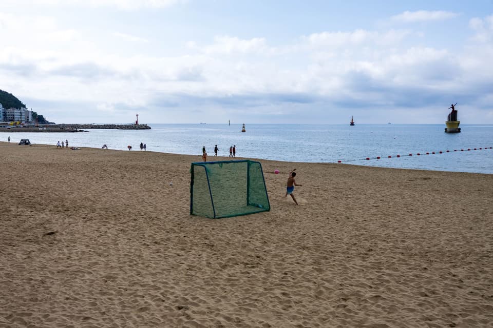 People enjoying a sunny day at Haeundae Beach, Busan, South Korea.