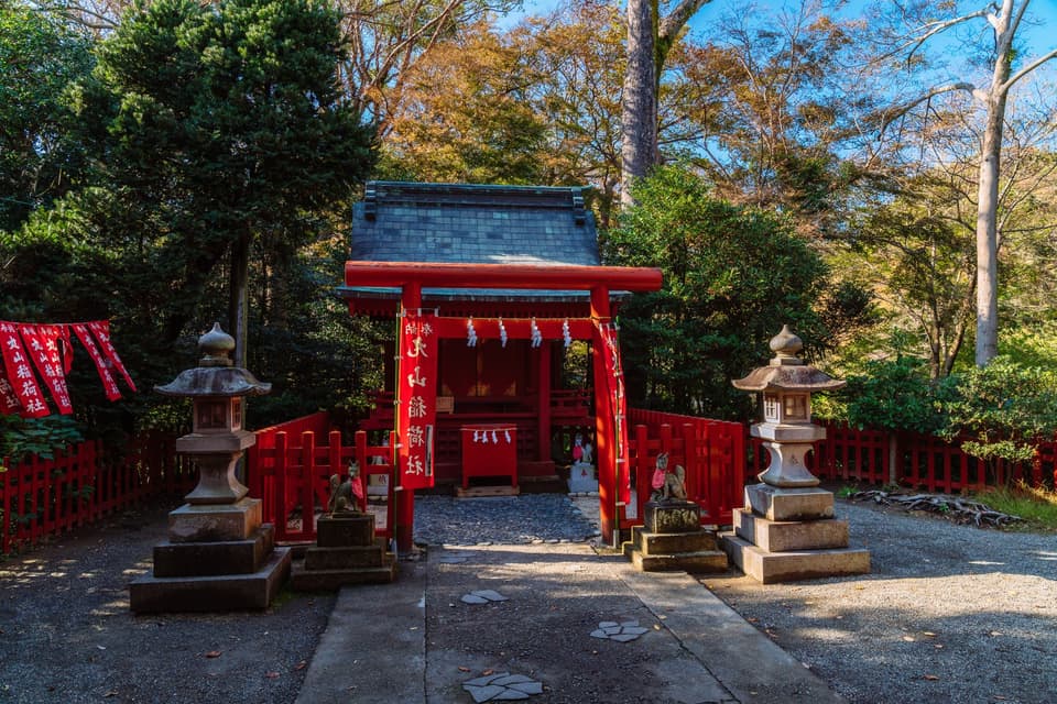 Serene view of a traditional Japanese shrine entrance in Kamakura, Japan, surrounded by nature.