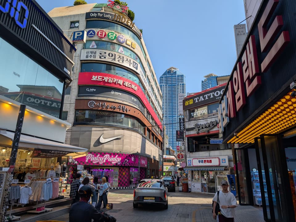 Lively shopping street in Busan, South Korea, showcasing diverse stores and urban architecture.