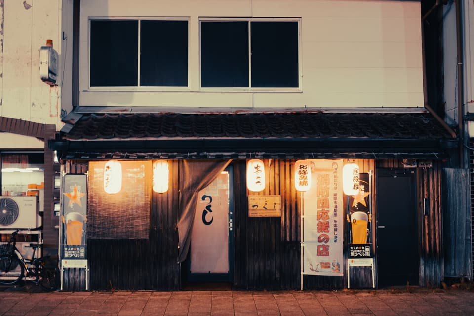 Cozy street view of a Japanese izakaya illuminated by lanterns in Ayabe, Kyoto.