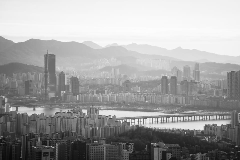 A stunning black and white view of Seoul's skyline featuring the Hangang River and modern skyscrapers.