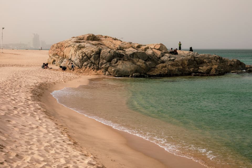 Serene beach landscape with rock formations at Jeongdongjin, ideal for tranquil coastal imagery.