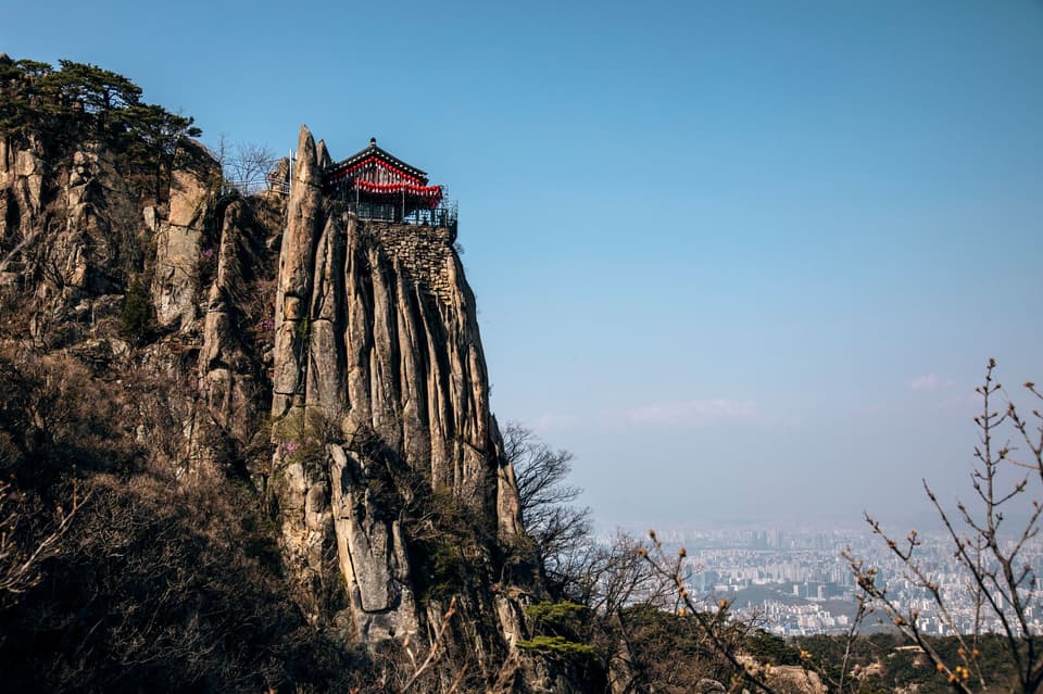 Stunning cliffside view over Seoul from a traditional Korean viewing deck.
