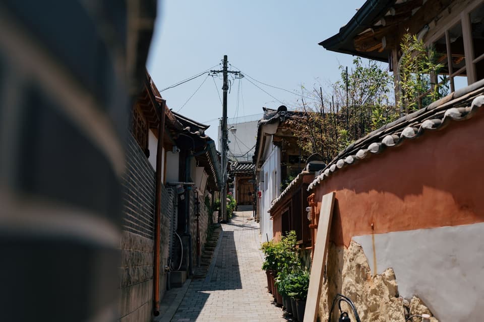 Charming alleyway in a South Korean Hanok village on a sunny day.