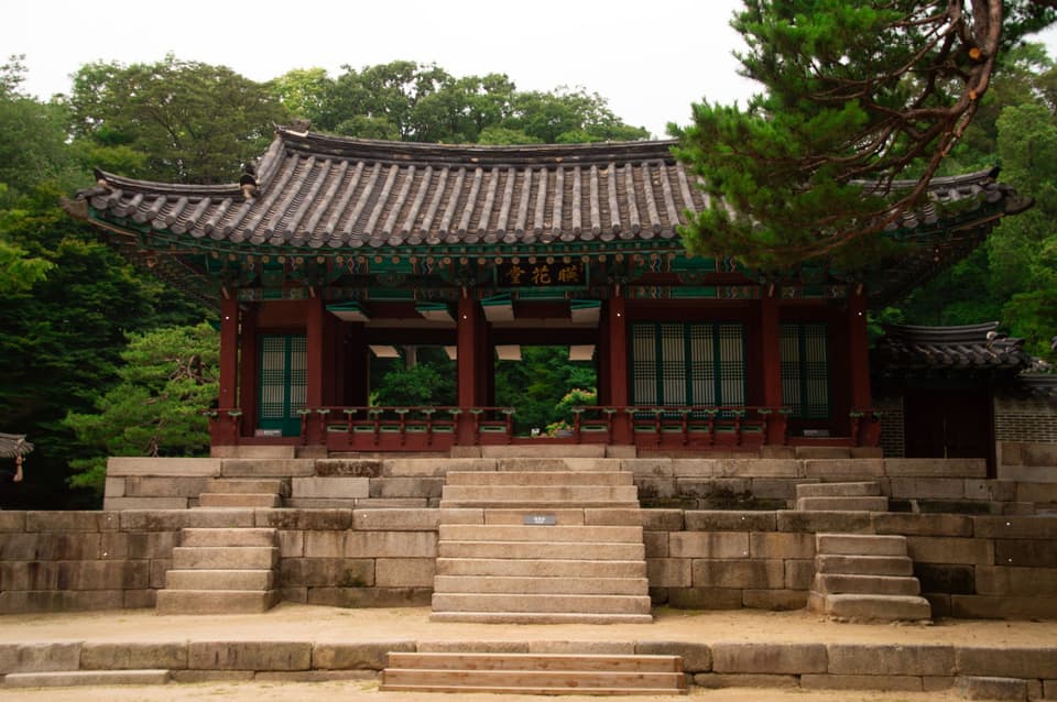 Elegant Korean temple structure surrounded by lush greenery in Seoul, South Korea.