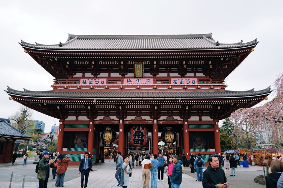 Visitors walk through the iconic Hozomon Gate at the historic Senso-ji Temple in Tokyo.