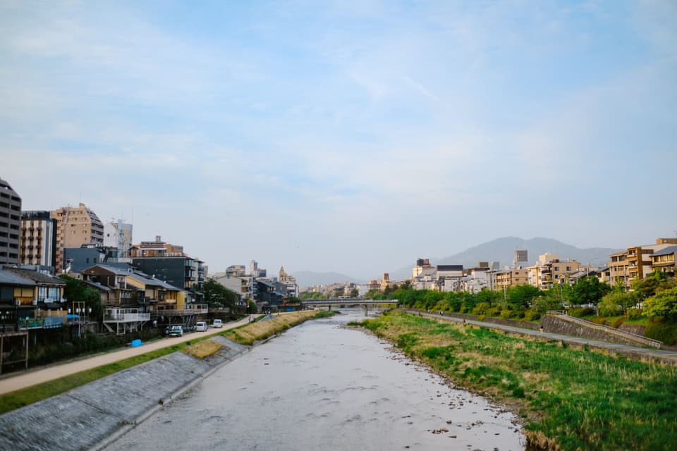 A picturesque view of the Kamo River with traditional architecture in Kyoto, Japan.