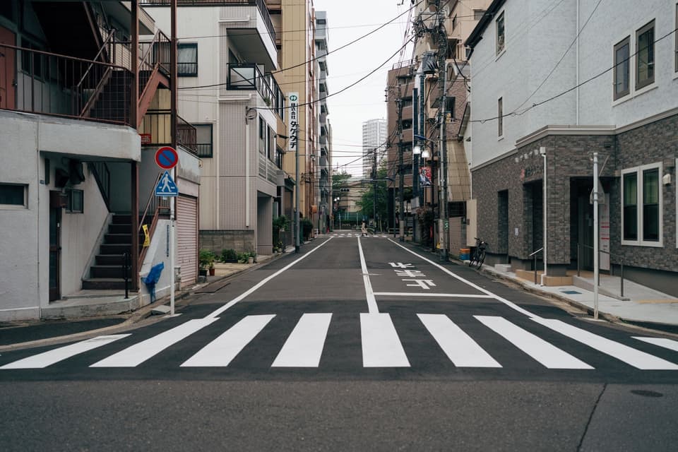 Tokyo city street with crosswalk and urban architecture, portraying Tokyo's urban atmosphere.