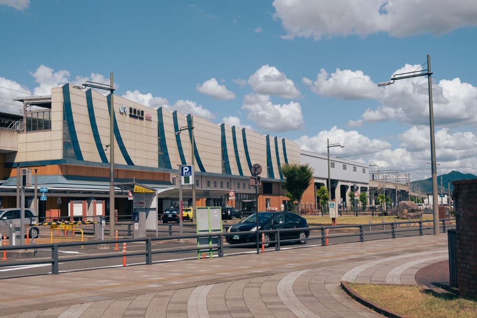 Exterior view of Fukuchiyama Station in Kyoto, showcasing modern architecture under a bright sky.
