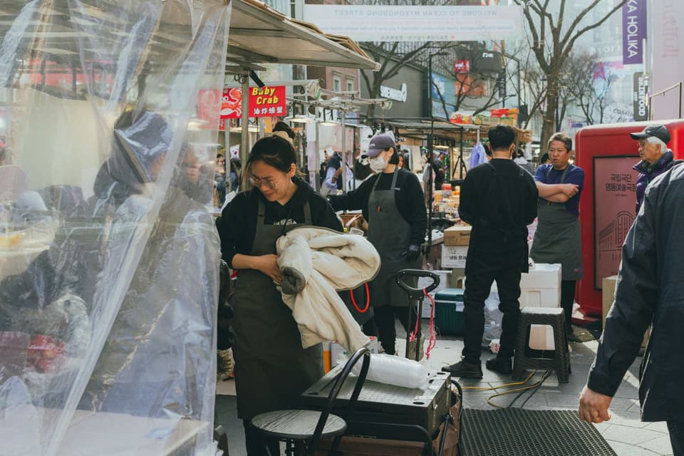 Explore the lively street market scene in Myeongdong, Seoul, showcasing Korean culture and culinary delights.
