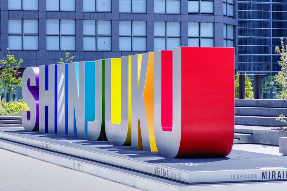 Vibrant Shinjuku sign in front of modern skyscrapers in Tokyo, Japan.