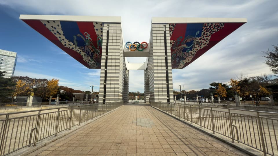 The striking World Peace Gate in Seoul's Olympic Park with vibrant fall colors.