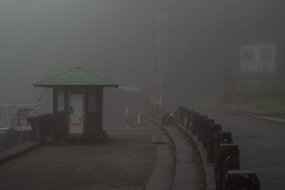 A foggy morning scene in Hakone, Japan, highlighting tranquility with mist-covered roads.