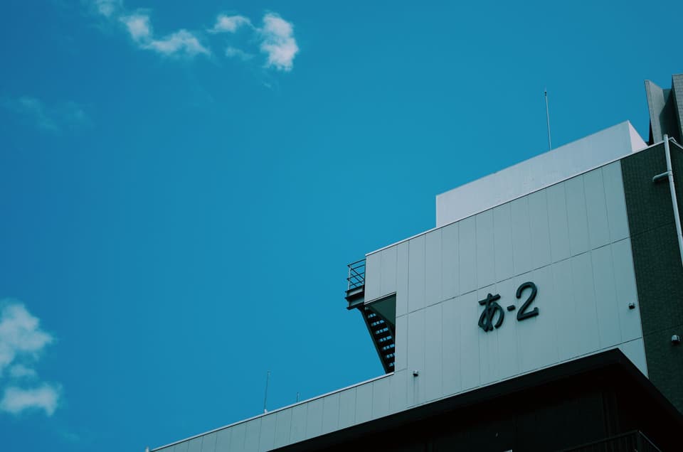 A minimalist view of a building in Tokyo, Japan with a blue sky background.