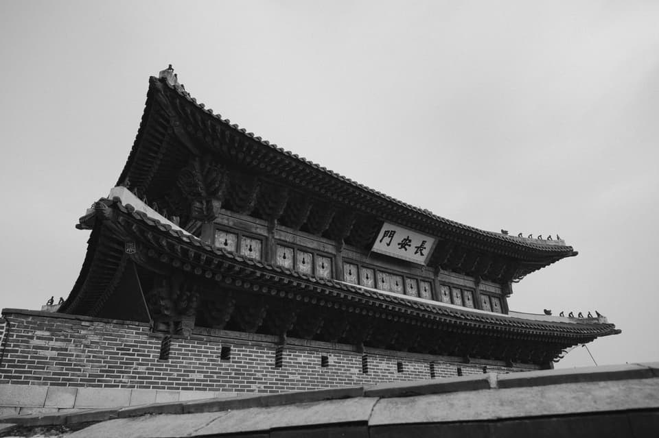 Black and white photo of Gyeongbokgung Palace in Seoul, showcasing traditional Korean architecture.
