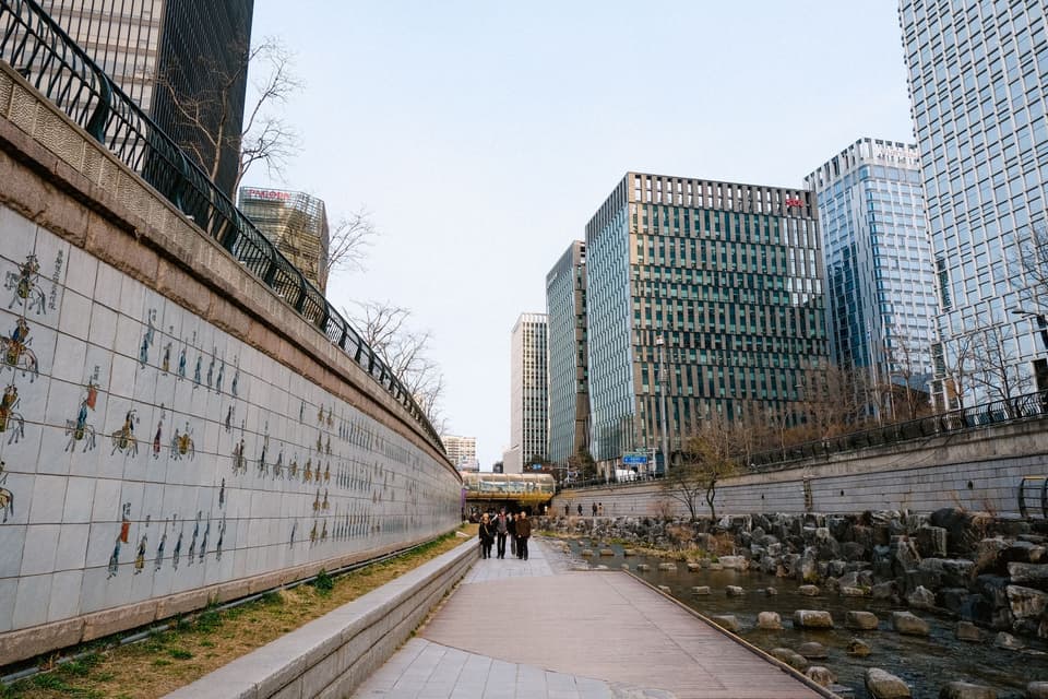 Riverwalk alongside modern Seoul skyscrapers, showcasing urban architecture and culture.
