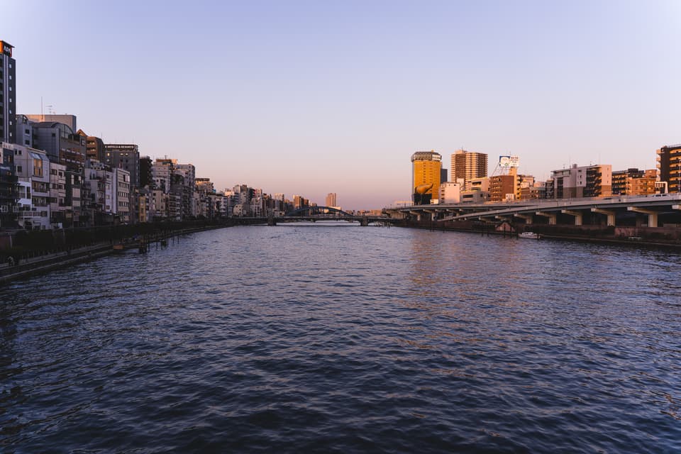 Stunning view of Sumida River in Tokyo, Japan during golden hour with a scenic bridge.