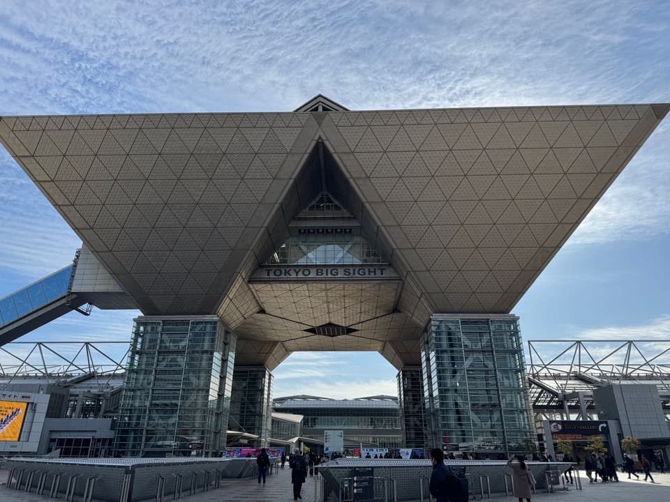 Tokyo Big Sight entrance showcasing unique architectural design under a clear blue sky.