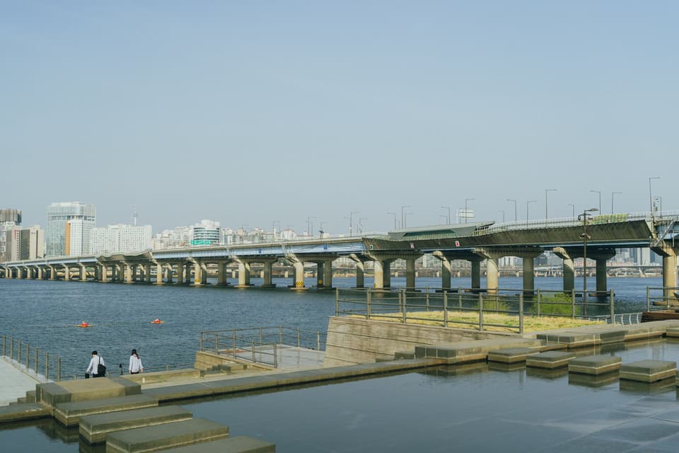 A serene view of a bridge spanning the Han River in Seoul, South Korea, on a clear day.