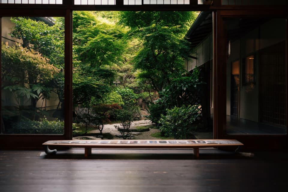 A serene view of a lush Japanese garden from a traditional Kyoto home, capturing natural beauty and cultural elegance.