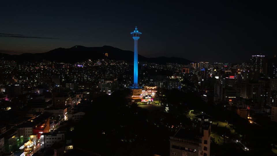 Stunning view of Busan Tower glowing over the city skyline at night.